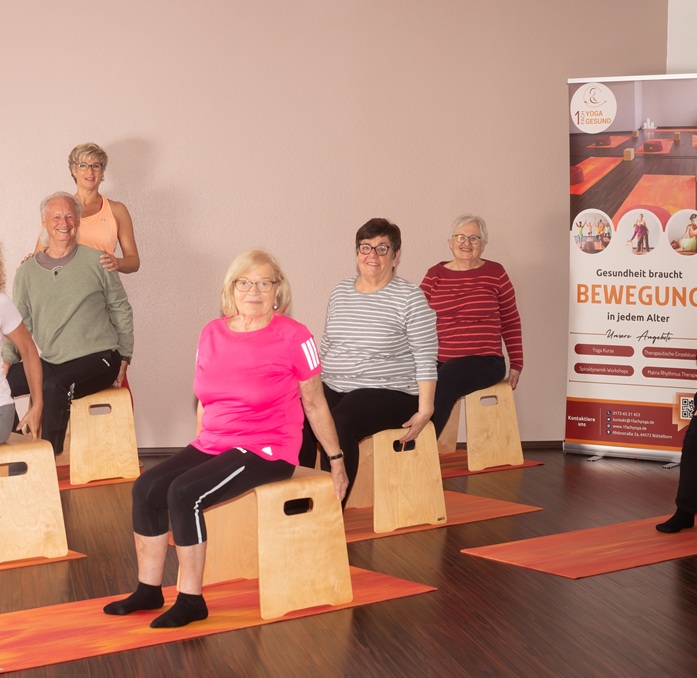 1fach Yoga | 1fach Gesund - Kurs Yoga auf dem Stuhl - Teilnehmergruppe bei Übung auf dem Hocker mit Silke Wagner